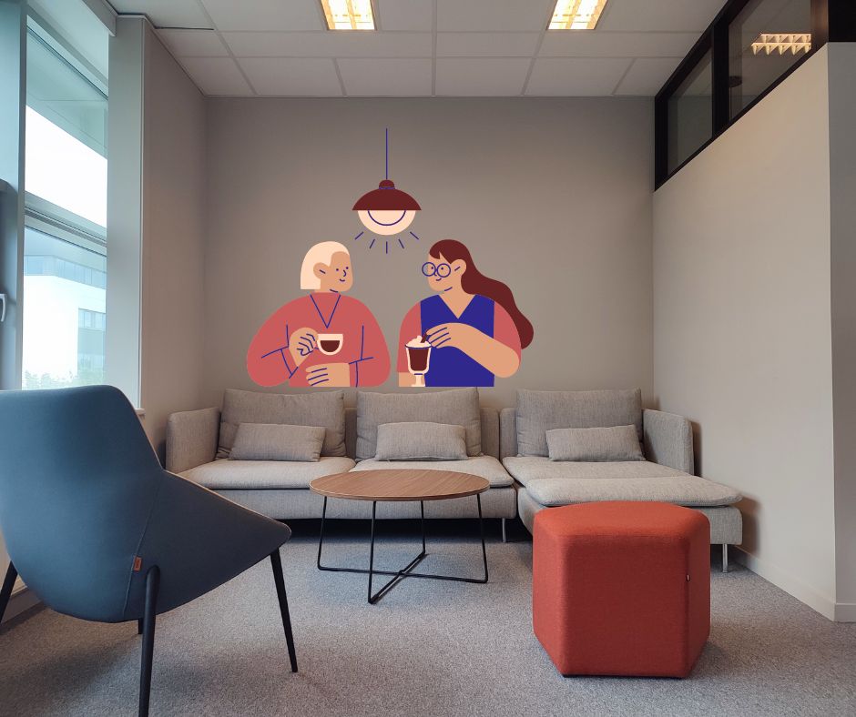 Photo d'un coin pause au travail composé d'un canapé, un fauteuil, un pouf et une table. Illustration de 2 personne prenant un café ensemble illustrant le fait de manger entre collègues.